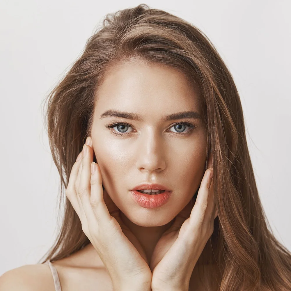 Close-up headshot of a woman displaying smooth under-eyes and voluminous lips from a Juvéderm dermal filler treatment.