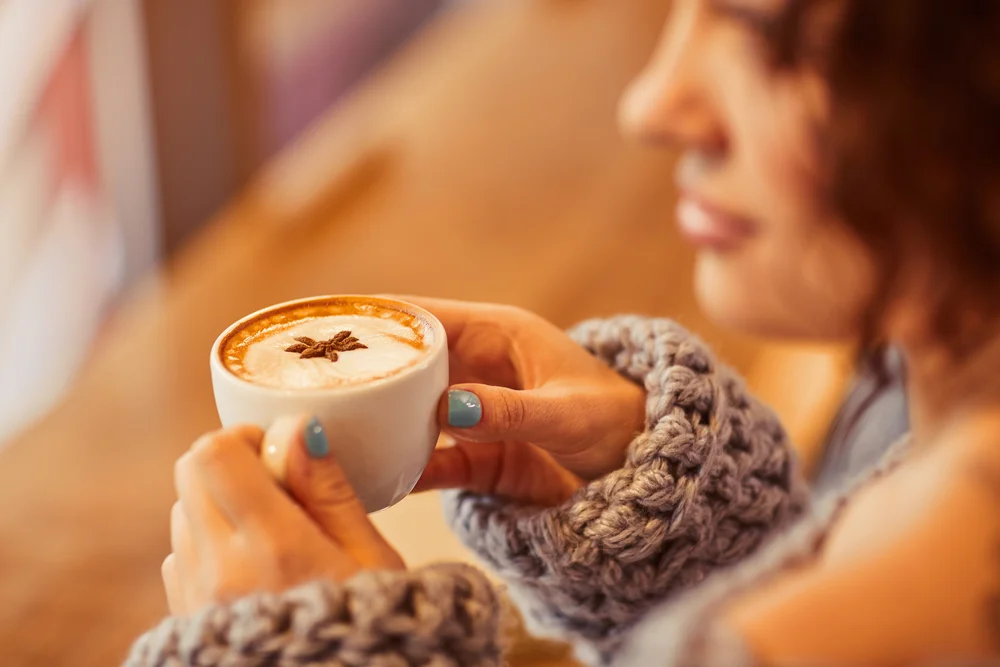 Relaxed woman holding a warm beverage, highlighting natural energy enhancement and immune support from IV vitamin therapy in Beverly Hills.