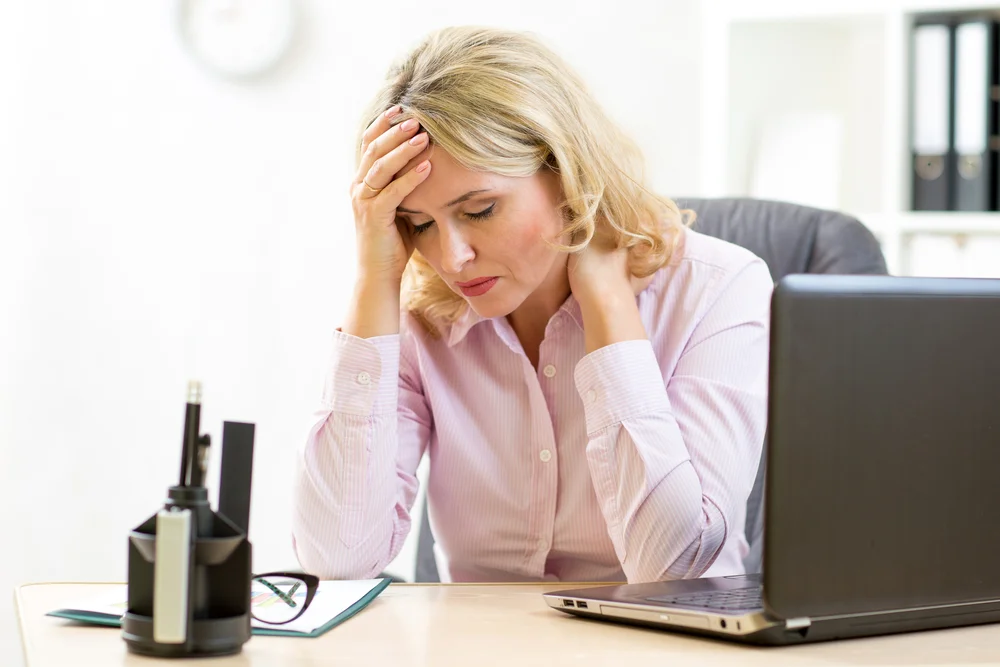 Stressed woman resting her head in her hands, representing cognitive health support and functional medicine treatments for brain fog.