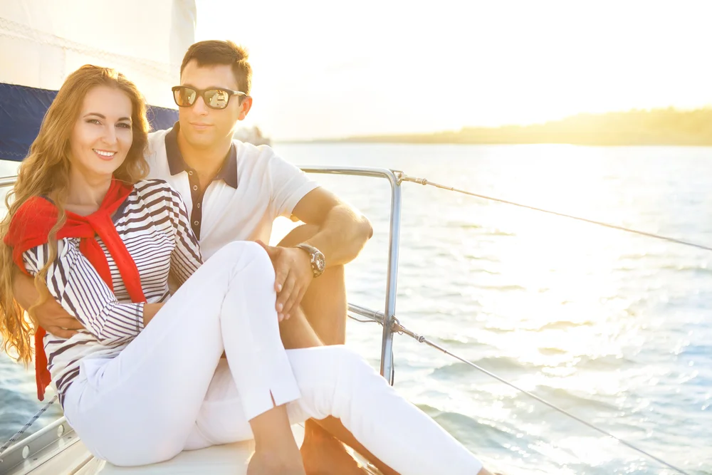 Happy couple walking together on a sunny beach, showcasing long-term health and vitality from a comprehensive custom anti-aging program.